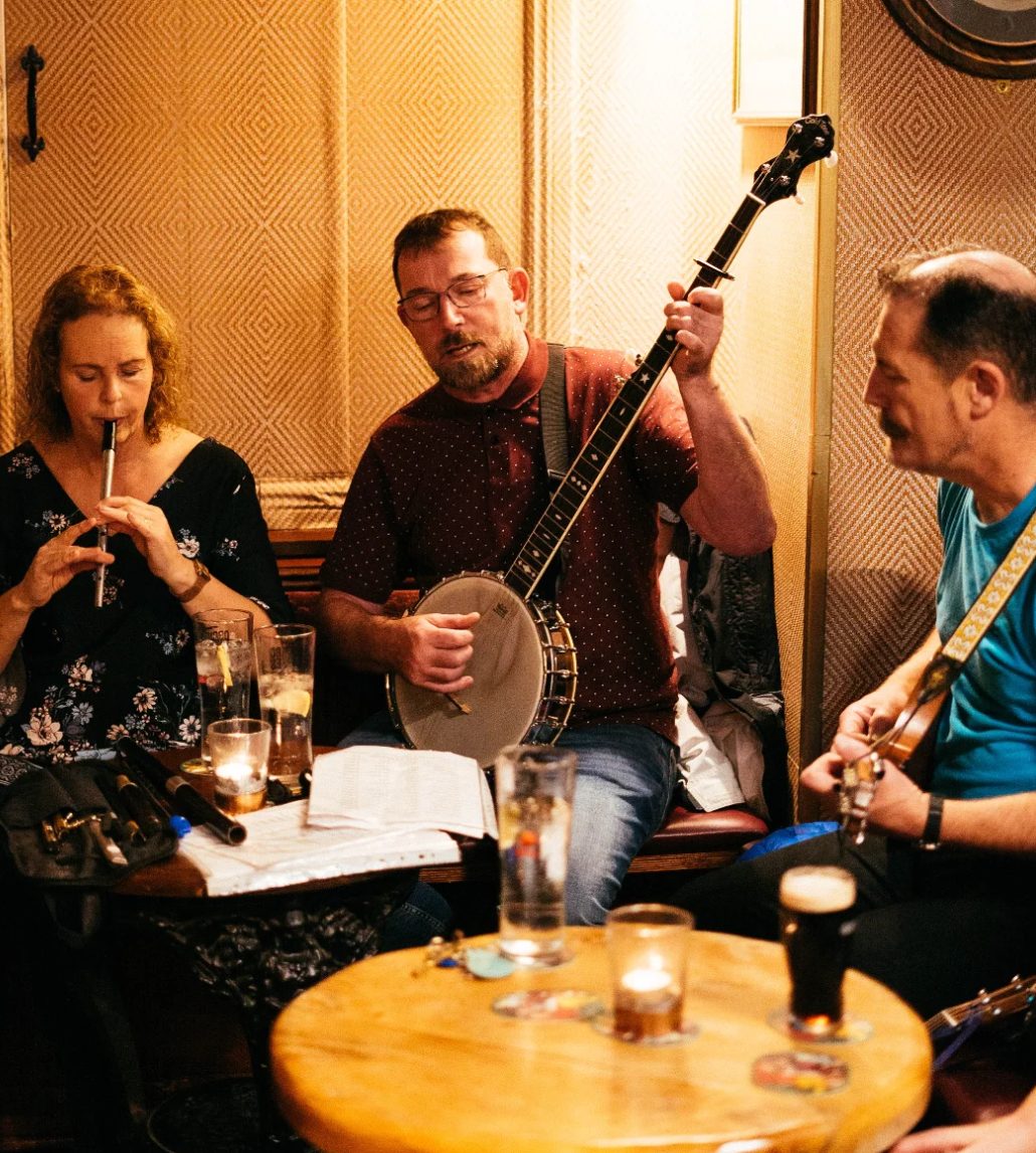 An Bhailiú playing flute, banjo and guitar during a pub session